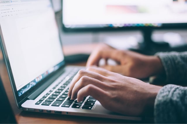 Hände am Computer beschreibt Texte als Service Angebot